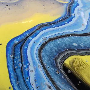 Abstract art with flowing yellow, blue, and black swirls.