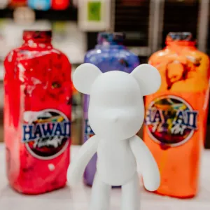 White bear figure in front of colorful painted bottles.